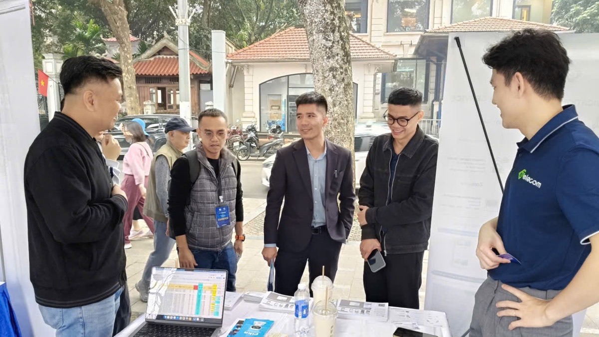 Doanh nghiệp và khách tham quan trao đổi bên bàn trưng bày trên phố đi bộ hồ Hoàn Kiếm
